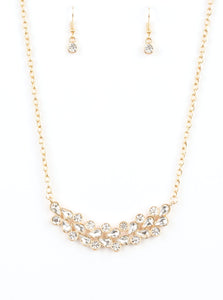 A collection of round and teardrop white rhinestones coalesce into a bowing gold pendant below the collar for a refined look. Features an adjustable clasp closure.  Sold as one individual necklace. Includes one pair of matching earrings.
