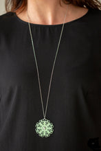 Load image into Gallery viewer,  Brushed in a flirty green finish, a filigree filled pendant swings from the bottom of a lengthened silver chain for a seasonal look. Features an adjustable clasp closure.  Sold as one individual necklace. Includes one pair of matching earrings.