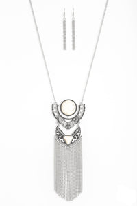   Featuring refreshing white stone accents, ornate silver plates link at the bottom of a lengthened silver chain for a dramatic tribal look. Shimmery silver chains stream from the bottom of the stacked pendant, adding a wanderlust flair to the seasonal palette. Features an adjustable clasp closure.  Sold as one individual necklace. Includes one pair of matching earrings.  