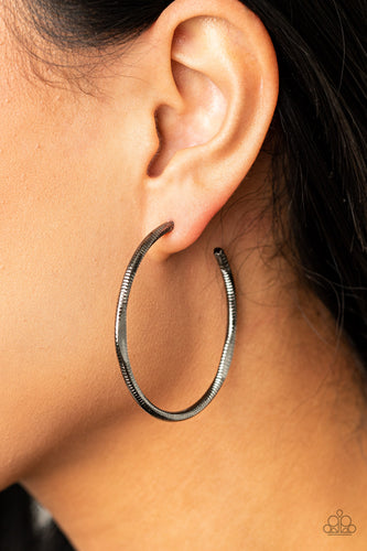 Featuring flattened sections, a textured gunmetal hoop boldly curls around the ear for an edgy flair. Earring attaches to a standard post fitting. Hoop measures approximately 1 3/4
