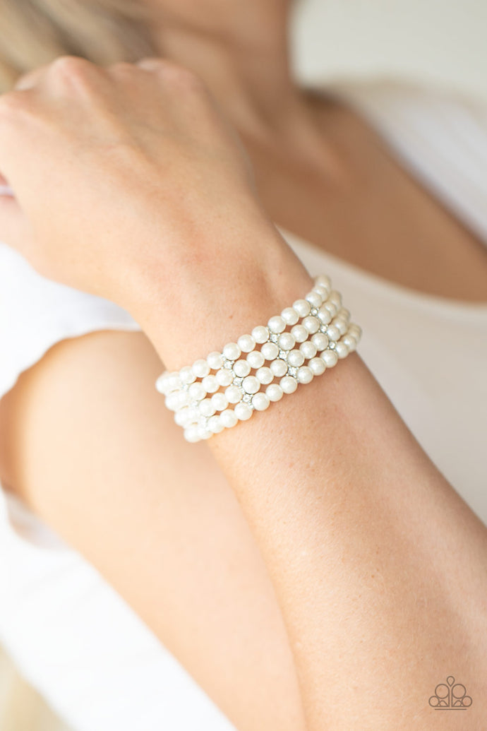Held together by glittery white rhinestone encrusted silver fittings, row after row of white pearls are threaded along stretchy bands around the wrist for a timelessly stacked look.  Sold as one individual bracelet.  Always nickel and lead free.