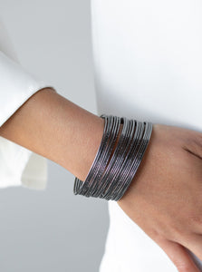 An assortment of smooth and hammered gunmetal bars arc across the wrist, stacking into a bold bangle-like cuff.  Sold as one individual bracelet.