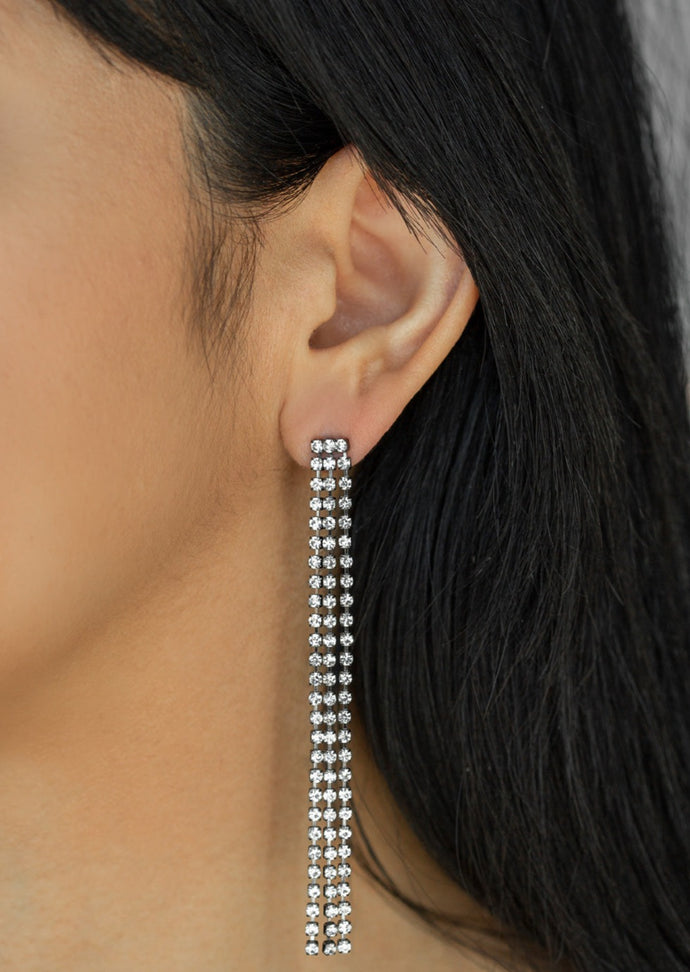 Three strands of glittery white rhinestones free-fall from the ear, coalescing into a timeless chandelier. Earring attaches to a standard post fitting.  Sold as one pair of post earrings.  