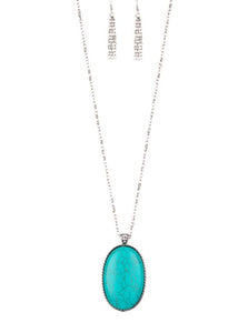 Chiseled into a tranquil oval, a dramatically over sized turquoise stone pendant swings from the bottom of a lengthened silver chain. Glassy white rhinestones dust the pendant's fitting for a refined flair. Features an adjustable clasp closure.  Sold as one individual necklace. Includes one pair of matching earrings.