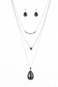 A textured silver bar is suspended horizontally from the uppermost chain above two stone pendants. A dainty black stone hangs from the center most layer as a black stone teardrop swings from the lowermost chain for a bold artisanal finish. Features an adjustable clasp closure.  Sold as one individual necklace. Includes one pair of matching earrings.