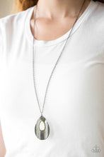 Load image into Gallery viewer,   Embossed in a linear geometric pattern, a warped gunmetal teardrop swings from the bottom of a lengthened gunmetal chain. Glittery green rhinestones are encrusted around the center of the teardrop pendant for a sparkling finish. Features an adjustable clasp closure.  Sold as one individual necklace. Includes one pair of matching earrings. Always nickel and lead free.