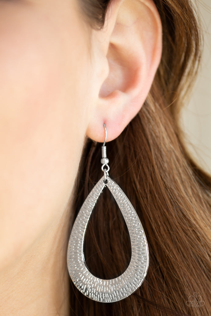 Etched in blinding shimmer, a glistening silver teardrop swings from the ear for a bold industrial look. Earring attaches to a standard fishhook fitting.  Sold as one pair of earrings.
