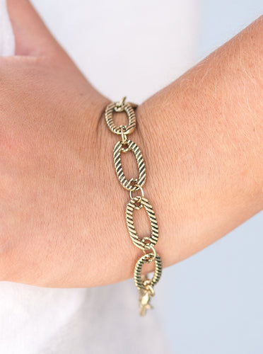 Etched in linear textures, shimmery brass frames link across the wrist in a modern industrial fashion. Features an adjustable clasp closure.  Sold as one individual bracelet.   