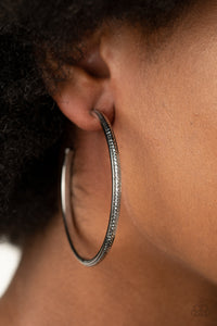 Featuring shimmery diamond-cut texture, a glistening gunmetal bar lines the center of a beveled gunmetal hoop, creating an edgy stacked look. Earring attaches to a standard post fitting. Hoop measures approximately 2 1/2" in diameter.  Sold as one pair of hoop earrings.  Always nickel and lead free.
