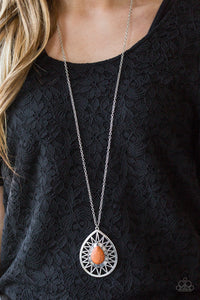   A vivacious orange stone is pressed into the center of a large silver teardrop radiating with shimmery sunburst patterns. The tribal inspired pendant swings from the bottom of a lengthened silver chain for a dramatic look. Features an adjustable clasp closure.  Sold as one individual necklace. Includes one pair of matching earrings.  Always nickel and lead free.