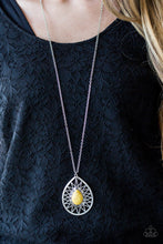 Load image into Gallery viewer,   A sunny yellow stone is pressed into the center of a large silver teardrop radiating with shimmery sunburst patterns. The tribal inspired pendant swings from the bottom of a lengthened silver chain for a dramatic look. Features an adjustable clasp closure.  Sold as one individual necklace. Includes one pair of matching earrings.  Always nickel and lead free.