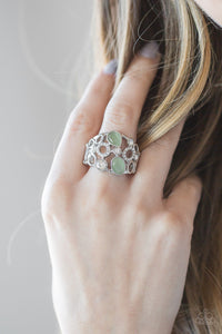 Shimmery silver frames, glassy white rhinestones, and glowing green moonstones coalesce across the finger, creating a bubbly frame. Features a stretchy band for a flexible fit.  Sold as one individual ring.  Always nickel and lead free.