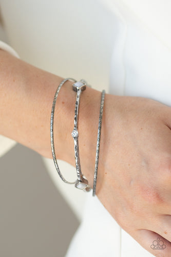   Infused with a pair of dainty textured bangles, a hammered silver bangle is encrusted in sections of glassy white rhinestones and square Paloma beads for a seasonal blend.  Sold as one set of three bracelets. Always nickel and lead free. 