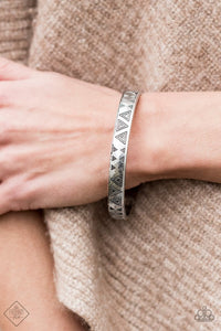 Brushed in an antiqued shimmer, decorative triangular patterns are stamped along a glistening silver bangle for a tribal inspired look.  Sold as one individual bracelet.   Sunset Sightings Fashion Fix   Always nickel and lead free.