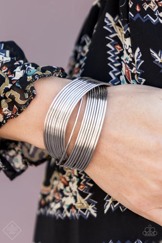 Threaded along two metallic rods, glistening silver bands crisscross across the wrist, creating the illusion of countless silver bangles in the convenience of a simple layered cuff.  Sold as one individual bracelet.