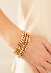  Lightweight and flirty, two strands of golden square beads interspersed with gold cylinders, are paired with two strands of gold cubes. The four stretchy bracelets come together to create an irresistible stack of metallic mayhem.
