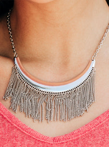 Brushed in an antiqued finish, glistening silver chains stream from the bottom of a silver crescent, creating a bold fringe below the collar for a fierce look. Features an adjustable clasp closure.  Sold as one individual necklace. Includes one pair of matching earrings.
