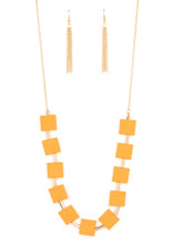 Load image into Gallery viewer, Vibrant geometric squares painted in the spring Pantone® of Marigold flare out along a long gold chain as it drapes along the chest. Sleek gold cylinders separate the square plates, adding warm metallic accents to the piece. Features an adjustable clasp closure.