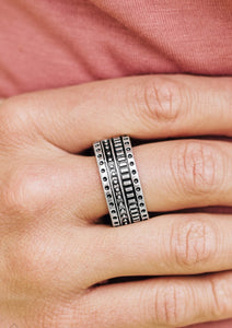 Dotted and studded in tribal inspired patterns, an antiqued silver band arcs across the finger in a handcrafted, artisan inspired fashion. Features a stretchy band for a flexible fit.  Sold as one individual ring.