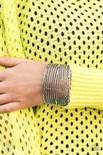 Load image into Gallery viewer, Bordered in crisscrossed details, hammering and smooth silver bars wrap back and forth across the wrist, coalescing into a thick silver cuff.