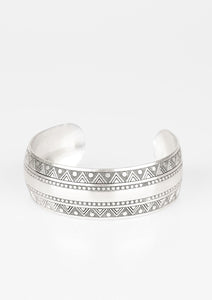 A thick silver cuff etched and embossed in dizzying triangular patterns, wraps boldly around the wrist to create a strong statement piece..  Sold as one individual bracelet.