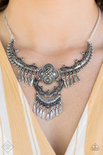 Load image into Gallery viewer, A collection of antiqued silver plates connects below the collar, joining into an elaborate pendant. The floral dotted frames give way to sections of silver beaded fringe, adding hints of movement to the tribal inspired piece. Features an adjustable clasp closure.