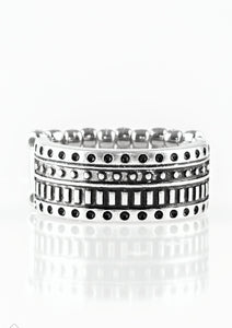 Dotted and studded in tribal inspired patterns, an antiqued silver band arcs across the finger in a handcrafted, artisan inspired fashion. Features a stretchy band for a flexible fit.  Sold as one individual ring.