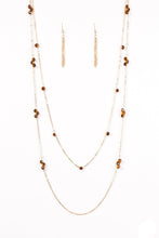 Load image into Gallery viewer, Brown crystal-like beads trickle along two strands of shimmery gold chain, creating glittery accents across the chest. Features an adjustable clasp closure.  Sold as one individual necklace. Includes one pair of matching earrings.