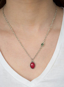 A faceted red bead swings from the bottom of a shimmery silver chain. A smoky rhinestone adorns one side for a sleek asymmetrical finish. Features an adjustable clasp closure.  Sold as one individual necklace. Includes one pair of matching earrings.