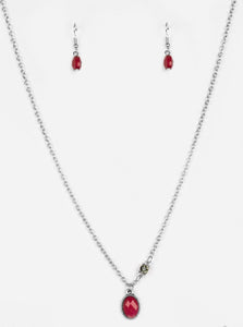 A faceted red bead swings from the bottom of a shimmery silver chain. A smoky rhinestone adorns one side for a sleek asymmetrical finish. Features an adjustable clasp closure.  Sold as one individual necklace. Includes one pair of matching earrings.