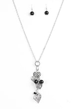 Load image into Gallery viewer, Filigree filled heart charms trickle along a silver chain, creating a whimsically stacked pendant. Polished black beading trickles between the hearts for a colorful finish. Features an adjustable clasp closure.  Sold as one individual necklace. Includes one pair of matching earrings.