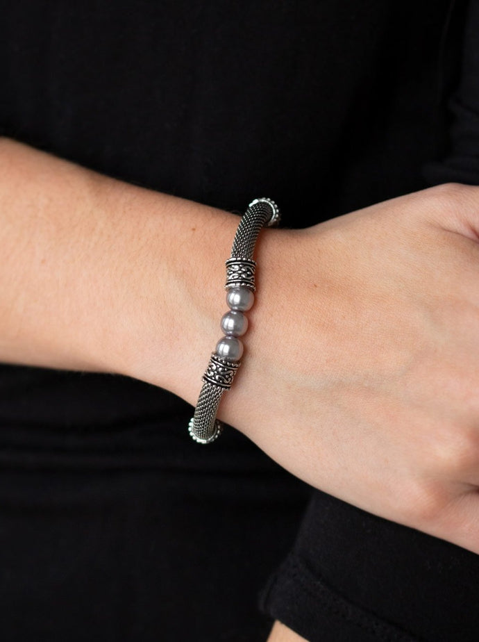 Pearly silver beads, ornate silver accents, and sections of silver mesh chain are threaded along a stretchy band around the wrist for a refined flair.  Sold as one individual bracelet.  