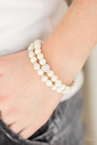 Polished and pearly white beads are threaded along stretchy elastic bands. Encrusted in glassy white rhinestones, silver rings and glittery white beads are sprinkled between the white accents for a refined finish.  Sold as set of two bracelets.  Always nickel and lead free.