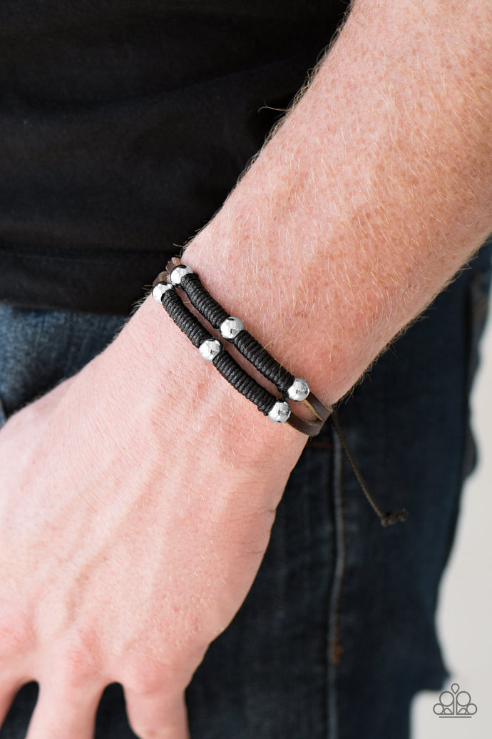 Black cording wraps around two skinny leather bands, securing classic silver beads in place for a ruggedly layered look. Features an adjustable sliding knot closure.  Sold as one individual bracelet.  Always nickel and lead free.