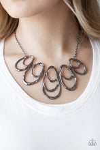 Load image into Gallery viewer, Delicately hammered gunmetal bars overlap into a collection of asymmetrical teardrops below the collar, creating a bold artisan inspired fringe. Features an adjustable clasp closure.  Sold as one individual necklace. Includes one pair of matching earrings.  Always nickel and lead free.