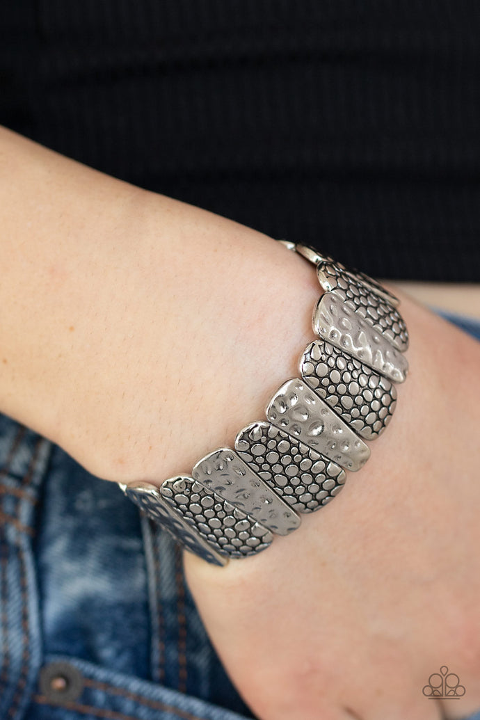 Hammered and embossed in antiqued patterns, asymmetrical silver frames are threaded along stretchy bands around the list for seasonal look.  Sold as one individual bracelet.  Always nickel and lead free.