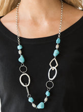 Load image into Gallery viewer, Bits of refreshing turquoise stones and ornate silver beading give way to asymmetrical silver frames. The mismatched frames drape across the chest, creating an earthy collision of rock and metal. Features an adjustable clasp closure.  Sold as one individual necklace. Includes one pair of matching earrings.  