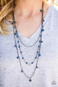 A glistening gunmetal chain gives way to layers of gunmetal chains featuring blue pearls. Varying in shape and shimmer, the mismatched chain drape across the chest in a refined fashion. Features an adjustable clasp closure.  Sold as one individual necklace. Includes one pair of matching earrings.  