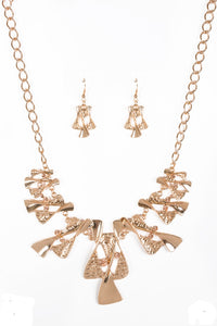 Twisted gold hourglasses dance along a chunky gold chain with tiny peach rhinestones adding sparkling, elegant accents. Beautiful textured pieces add depth to the design. Features an adjustable clasp closure.  Sold as one individual necklace. Includes one pair of matching earrings.