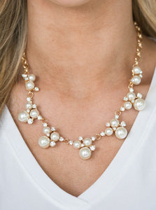Clusters of pearls and dazzling white rhinestones join below the collar, creating refined frames. Infused with a glistening gold chain, the sections of luminescent frames trickle along the neck in a timeless fashion. Features an adjustable clasp closure.  Sold as one individual necklace. Includes one pair of matching earrings.  Life of the Party Exclusive  