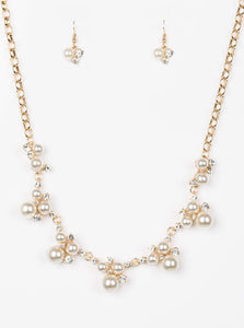 Clusters of pearls and dazzling white rhinestones join below the collar, creating refined frames. Infused with a glistening gold chain, the sections of luminescent frames trickle along the neck in a timeless fashion. Features an adjustable clasp closure. Sold as one individual necklace. Includes one pair of matching earrings. Life of the Party Exclusive