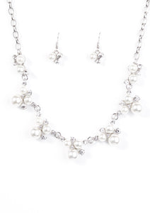 Clusters of pearls and dazzling white rhinestones join below the collar, creating refined frames. Infused with a glistening silver chain, the sections of luminescent frames trickle along the neck in a timeless fashion. Features an adjustable clasp closure.  Sold as one individual necklace. Includes one pair of matching earrings.