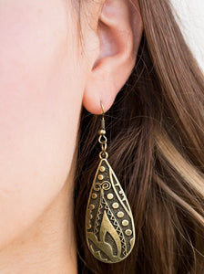 Embossed in tactile textures, a glistening brass teardrop swings from the ear in a seasonal fashion. Earring attaches to a standard fishhook fitting.  Sold as one pair of earrings.