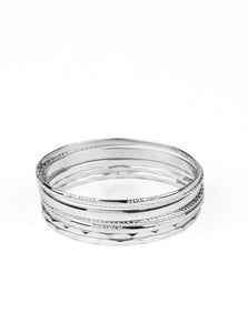 Featuring an array of smooth, hammered, and metallic rope-like textures, a mismatched collection of shiny silver bangles stacks across the wrist for a classic look.  Sold as one set of seven bracelets.  