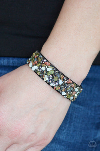 Bits of crushed natural stone is encrusted along the front of a black suede band. Smoky and hematite rhinestones are sprinkled along the band, adding edgy shimmer to the sassy seasonal palette. Features an adjustable snap closure.  Sold as one individual bracelet.  