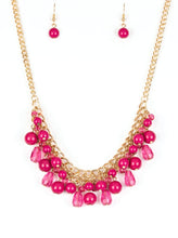 Load image into Gallery viewer, Varying in shape, glassy and polished pink beads swing from the bottom of interlocking gold chains. Crystal-like teardrops are sprinkled along the colorful beading, creating a flirtatious fringe below the collar. Features an adjustable clasp closure.  Sold as one individual necklace. Includes one pair of matching earrin