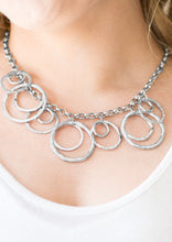 Load image into Gallery viewer, Featuring a subtle hammered finish, asymmetrical silver rings cascade from the bottom of a bold silver chain, creating a dizzying fringe below the collar. Features an adjustable clasp closure.  Sold as one individual necklace. Includes one pair of matching earrings. 