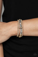 Load image into Gallery viewer, A collection of brown stone beads and faceted silver beads are threaded along stretchy bands around the wrist, creating earthy layers.  Sold as one set of three bracelets.  Always nickel and lead free.