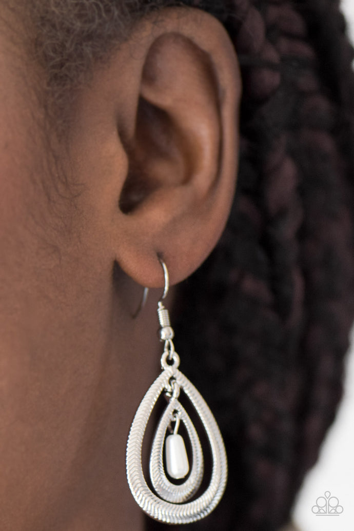 Etched in serrated shimmer, two silver teardrops drip from the ear in a refined fashion. A pearly white bead swings from the center of the airy lure, adding a colorful finish to the elegant palette. Earring attaches to a standard fishhook fitting.  Sold as one pair of earrings.  