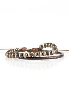 Brushed in a metallic shine, a strand of glistening beads and a strand of shiny leather cording wrap around the wrist, creating dainty layers. Features an adjustable sliding knot closure.  Sold as one individual bracelet.